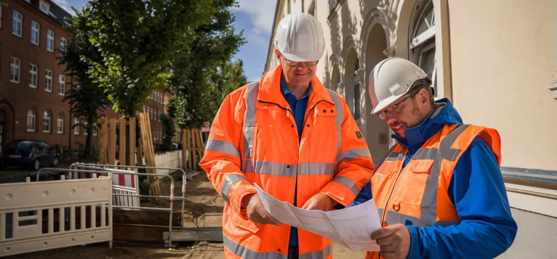 Zwei Mitarbeiter der Stadtwerke Schwerin besprechen einen Bauplan.