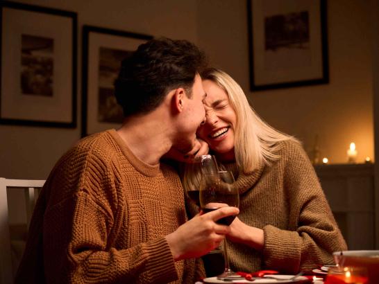 Ein Pärchen trinkt zuhause ein Glas Wein.