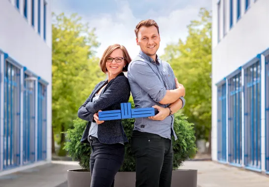 Mitarbeiter der Stadtwerke Schwerin halten das blaue SWS-Logo in den Händen.