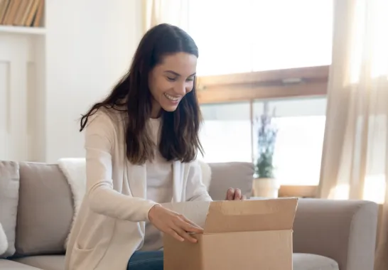 Eine Frau packt ein Paket aus.