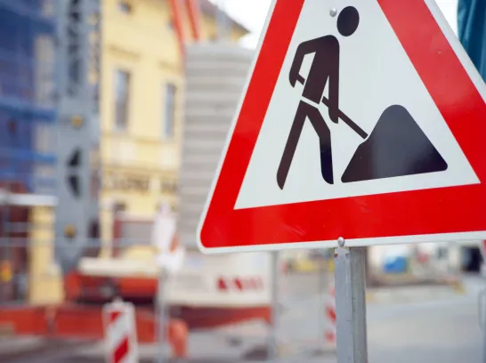 Ein Baustellenschild vor einer Baustelle in der Stadt.
