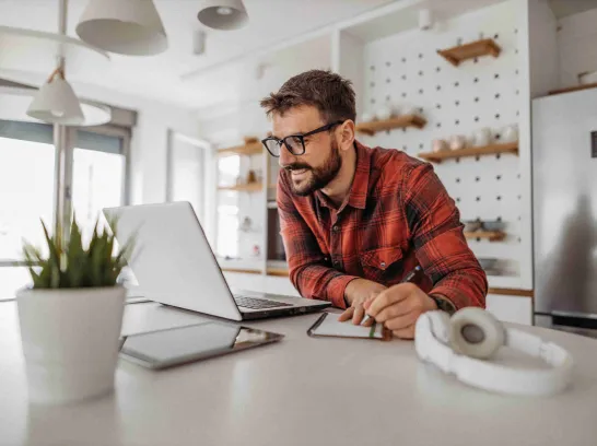 Ein Mann sitzt am Laptop und wechselt seinen Stromtarif.