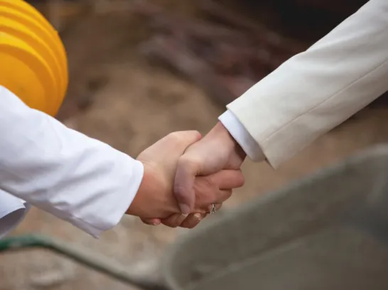 Zwei Menschen geben sich die Hand.