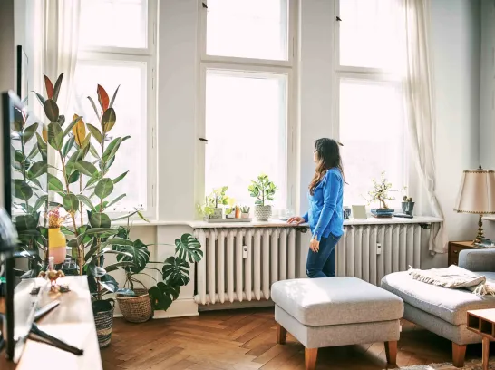 Eine Frau steht vor einer Heizung.