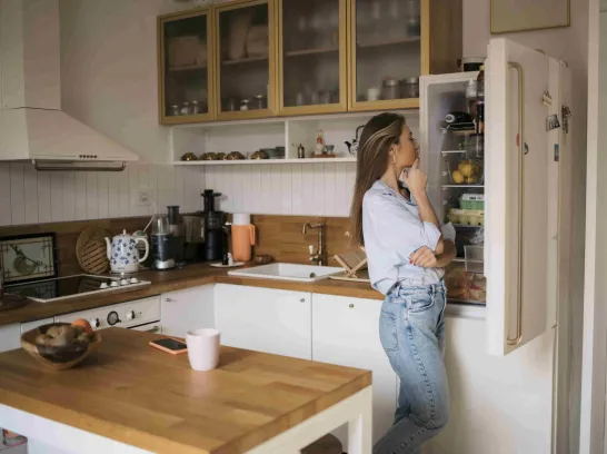 Eine Frau schaut in ihren Kühlschrank.