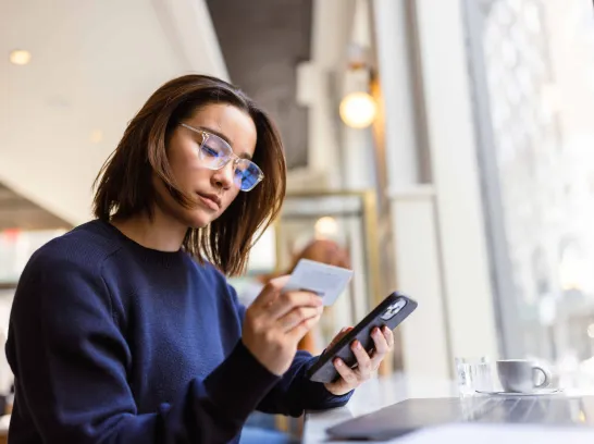 Frau bezahlt online auf Ihrem Handy.