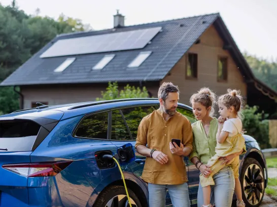 Familie lädt Elektroauto auf.