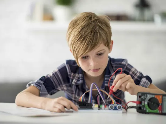 Ein Kind experimentiert am Tisch.