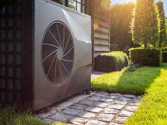 Eine Wärmepumpe steht im Garten.