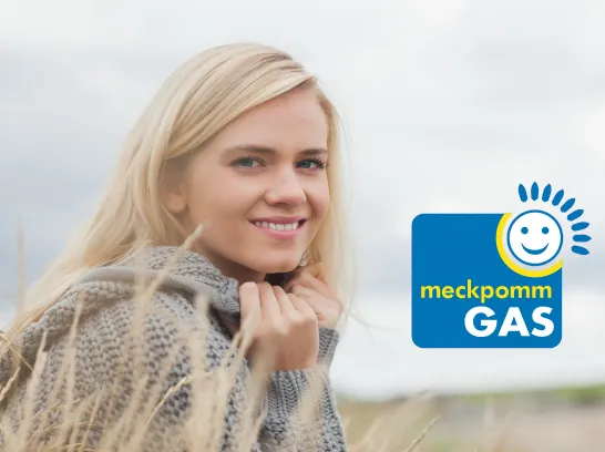 Eine junge Frau mit dickem Pullover am Strand. Unten rechts erscheint das meckpommGAS-Logo.