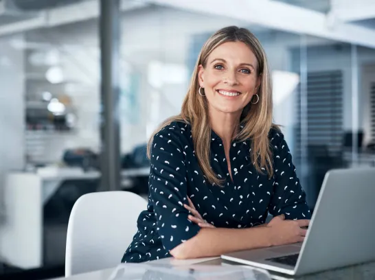 Eine Frau sitzt vor einem Laptop.