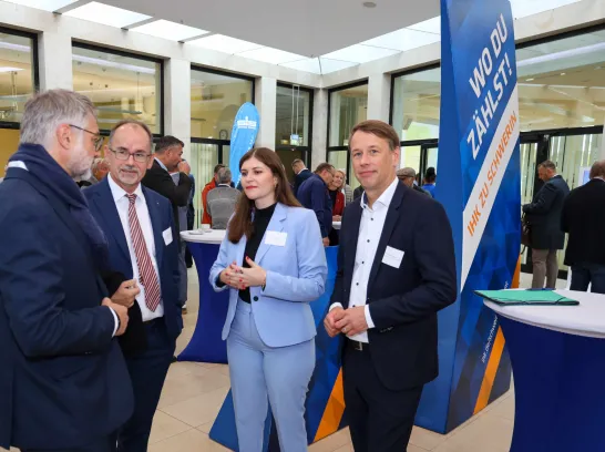 Gruppenbilder von vier Personen bei einer Geschäftsveranstaltung.