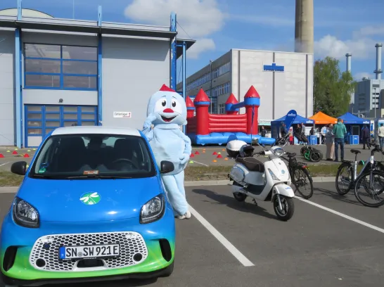 Maskottchen der Stadtwerke Schwerin steht im Elektrofuhrpark am Energiestandort Süd