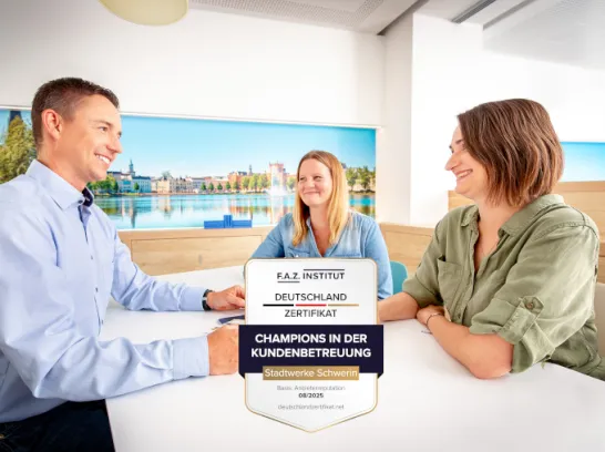 Ein Kundenbetreuer und zwei Kundinnen sitzen an einem Tisch im Gespräch