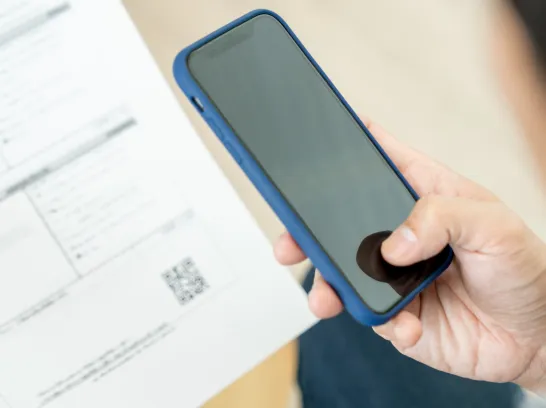 Eine Person scannt einen QR-Code mit einem Handy