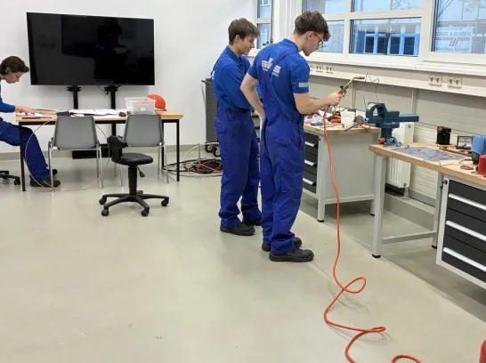 drei Auszubildende arbeiten in einer Lernwerkstatt