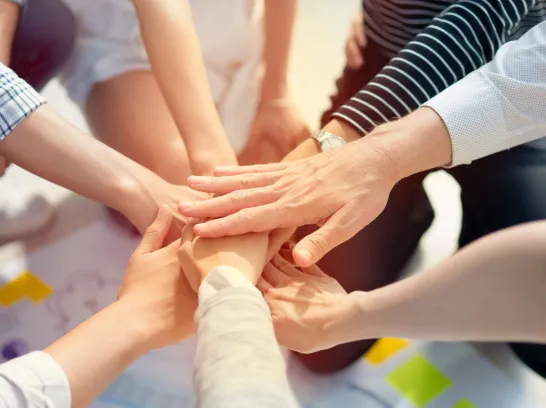 Viele Menschen legen die Hände aufeinander