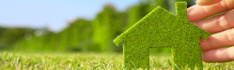 Hand hält grünes Haus aus Moos auf Rasen, Copyright: ponsulak_stock_adobe.com